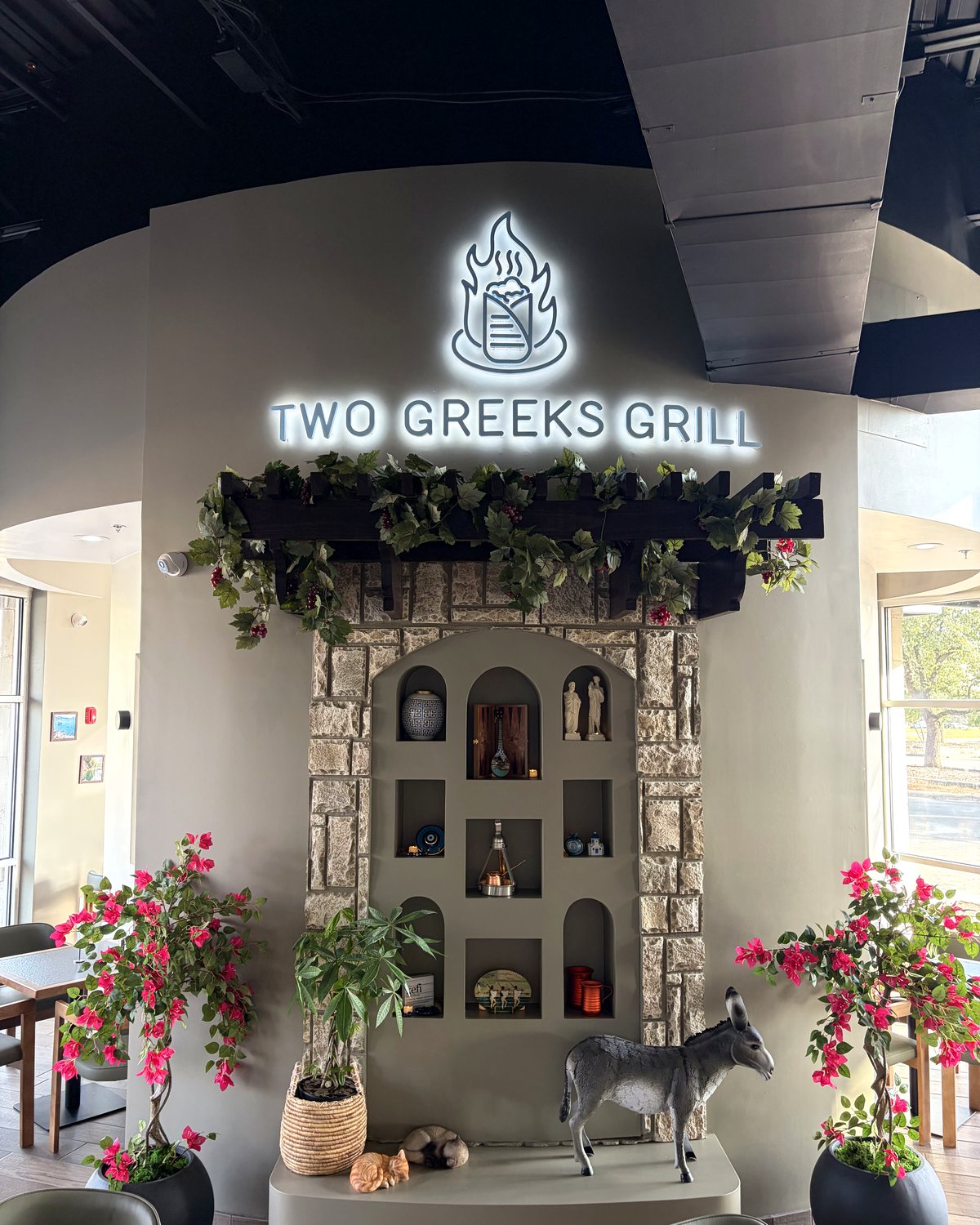 Two Greeks Grill dining room feature wall with logo and Greek decor