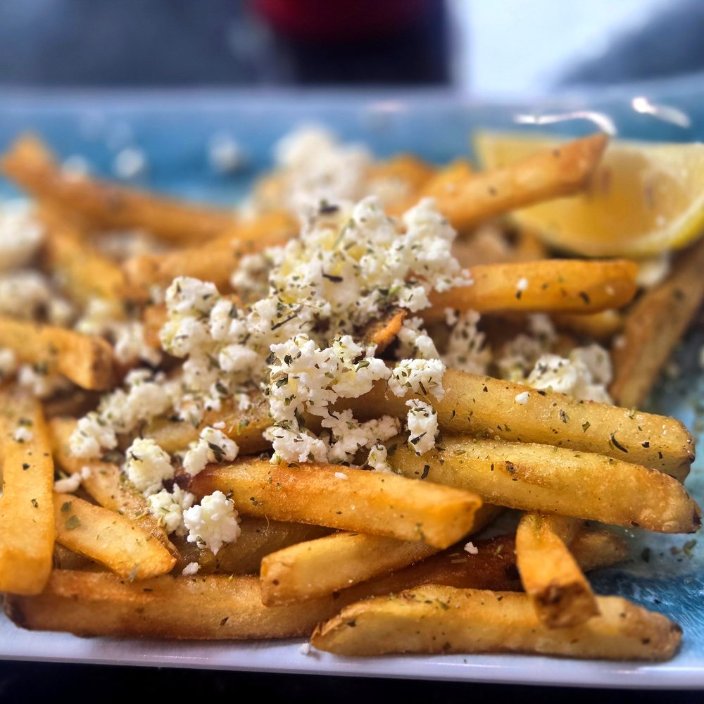 Feta fries topped with crumbled feta and oregano