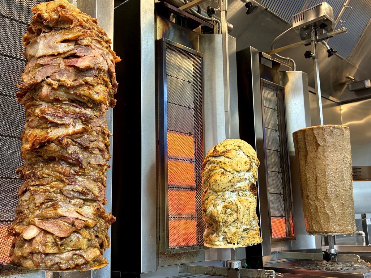 Gyro cone roasting on the vertical rotisserie at Two Greeks Grill